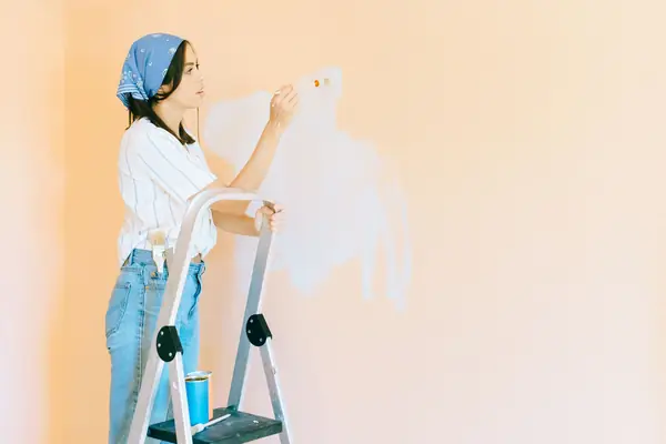 Interior painting in Green Bay: painter on a stepladder rolling a wall